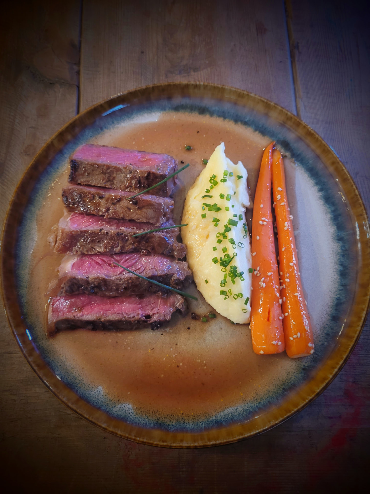 Sliced steak with glazed carrots and creamy mash